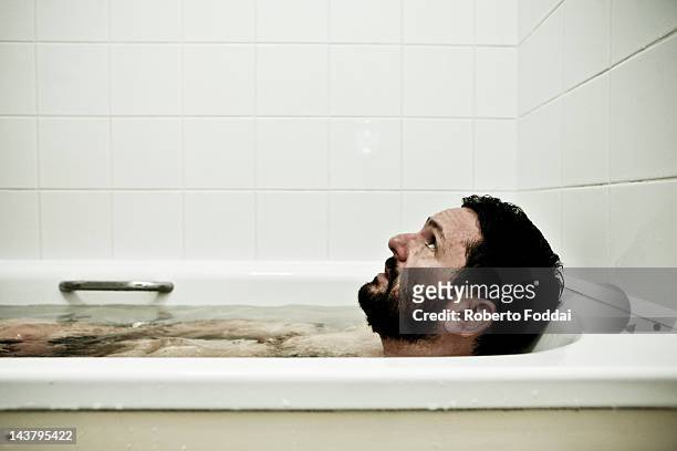 man in bathtub - hombre baño fotografías e imágenes de stock