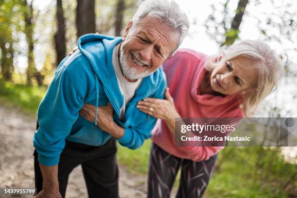 senior man suffering heart attack with wife along his side - male chest stock pictures, royalty-free photos & images