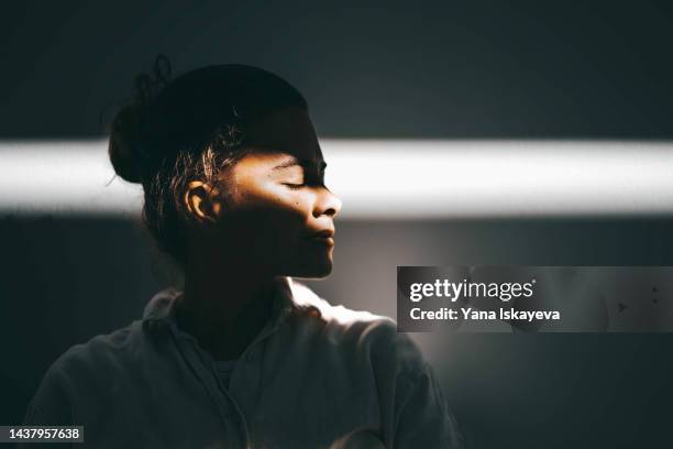 beautiful woman portrait against the sun ray, light and shadow play - work silhouette stock-fotos und bilder