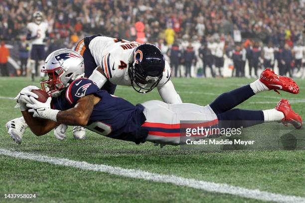 Jakobi Meyers of the New England Patriots dives across the goal line to score a 30-yard receiving touchdown as Eddie Jackson of the Chicago Bears is...