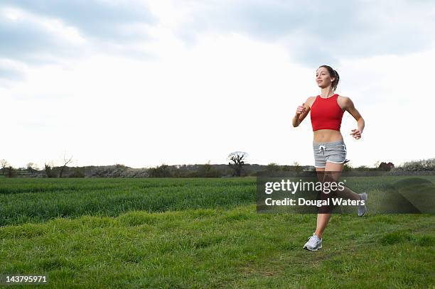 female athlete training in countryside. - running shorts stock pictures, royalty-free photos & images