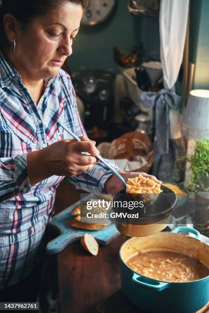 preparing french onion soup in domestic kitchen - onion soup stock pictures, royalty-free photos & images