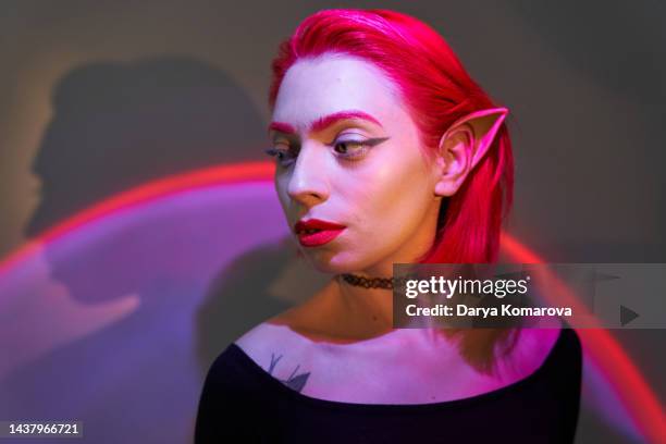 beautiful young woman with red hair, elf ears, red and purple light. digital age, neon light, the concept of the future, alien intelligence, computer games, virtual reality, disco night party. - alien portrait stock-fotos und bilder