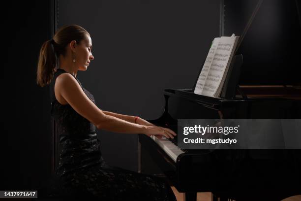 pianoforte a coda strumento musicale con esecutrice donna. - musical instrument foto e immagini stock