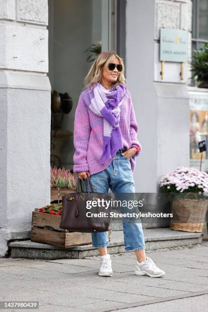 Influencer Gitta Banko wearing a pink and purple knitted pullover by Simone Bruns, a purple and pastel lavender scarf by Pur Schoen, light blue...