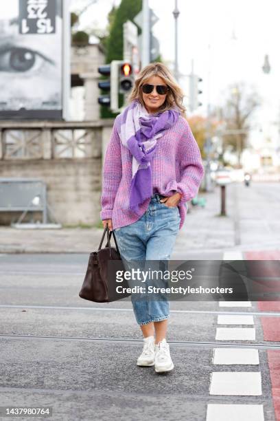 Influencer Gitta Banko wearing a pink and purple knitted pullover by Simone Bruns, a purple and pastel lavender scarf by Pur Schoen, light blue...
