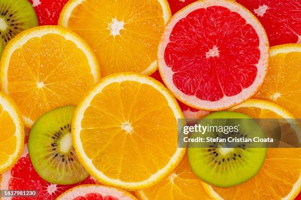 background of fresh sliced citrus fruits closeup - kiwi foto e immagini stock