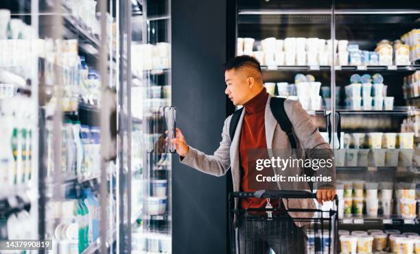 handsome asian man shopping after work in the supermarket - convenient store 個照片及圖片檔