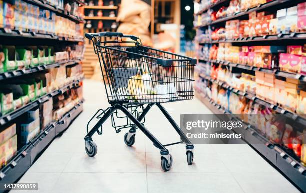 abandoned shopping cart with groceries - shopping trolley stock pictures, royalty-free photos & images