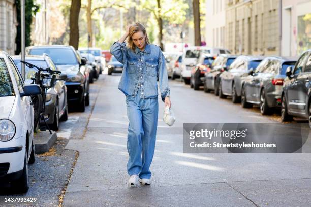 Model and influencer Marlies-Pia Pfeiffhofer, wearing a blue jeans blouse by Mango, a blue jeans by Mother, white sneakers by Nike, a white bag by...