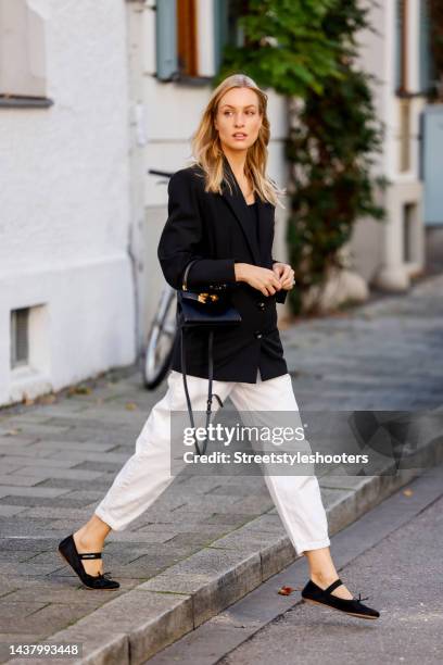 Model and influencer Marlies-Pia Pfeiffhofer, wearing a black balzer by Mango, a white jeans by Mango, black ballerinas by Miu Miu and a black bag by...