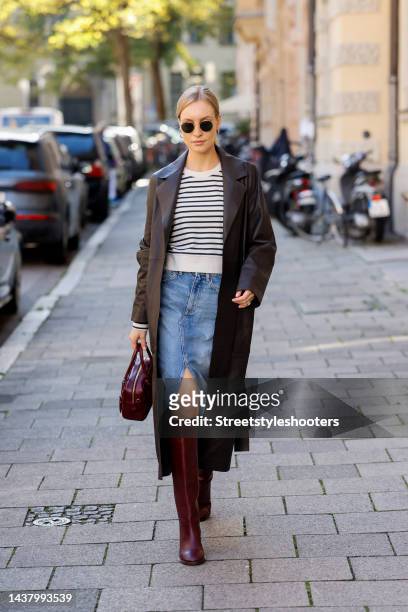 Model and influencer Marlies-Pia Pfeiffhofer, wearing a white pullover with black stripes by Veronica Beard, a blue jeans skirt by Mango, a dark...