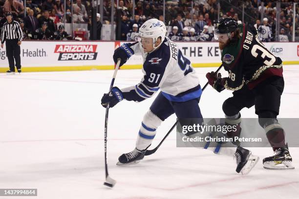 Cole Perfetti of the Winnipeg Jets shoots the puck ahead of Liam O'Brien of the Arizona Coyotes during the first period of the NHL game at Mullett...