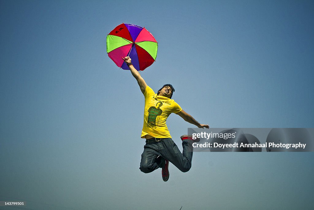 Young boy is jumping with an umbrella