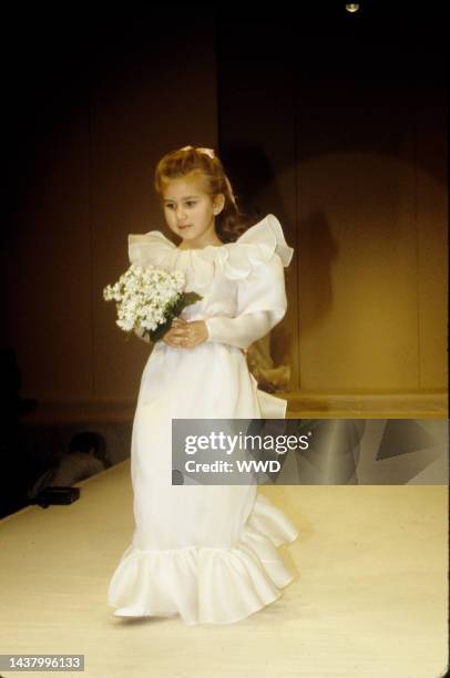 Flower girl in ruffled dress with boquet in the Oscar de la Renta Spring/Summer 1983 show in New York