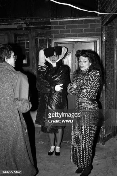 Designer Norma Kamali in an ethnic print dress with Ben Brantley and model wearing a puffy coat with large hat in New York