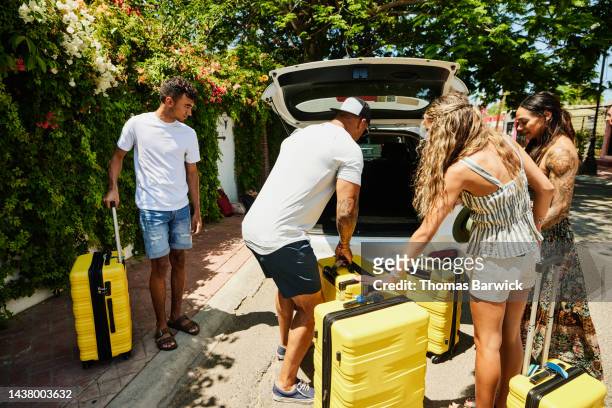wide shot of family loading rental car with luggage while on vacation - wide load stock pictures, royalty-free photos & images
