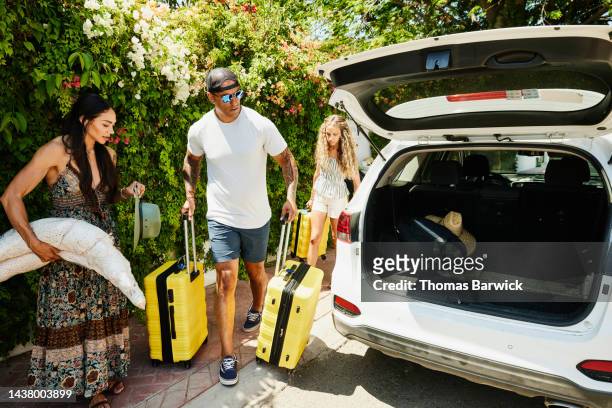 wide shot of family preparing to load rental car with luggage - family road trip car stock pictures, royalty-free photos & images