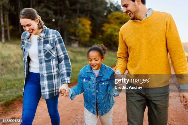 adoptive parents spending sunny autumn day with their daughter - foster stock pictures, royalty-free photos & images