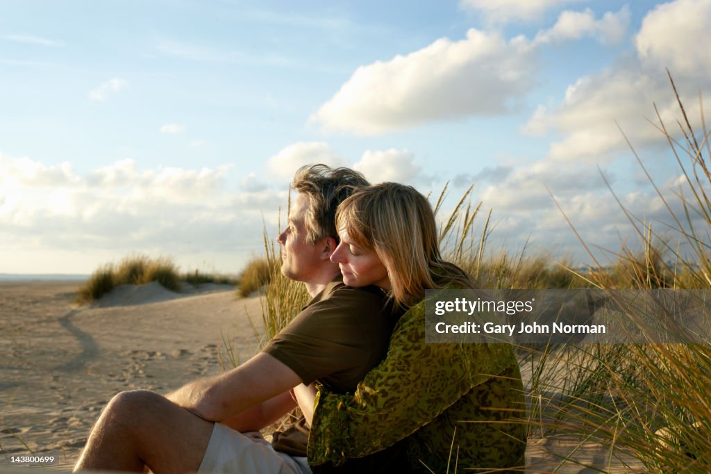 Couple sitting embracing on beach