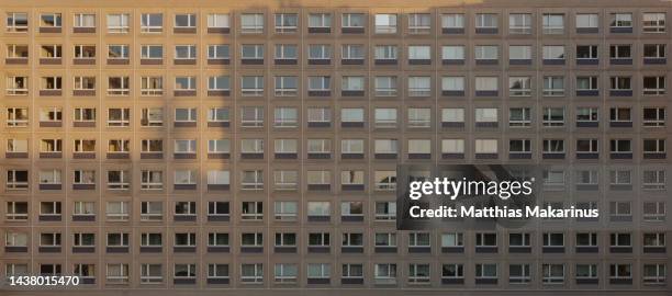 berlin city symmetry plattenbau residential building with shadow and sun light mix - fensterfront stock-fotos und bilder