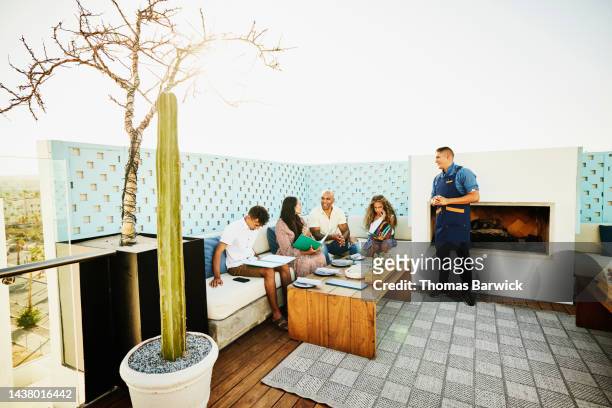 wide shot of family ordering dinner at outdoor restaurant at resort - choicepix stock pictures, royalty-free photos & images
