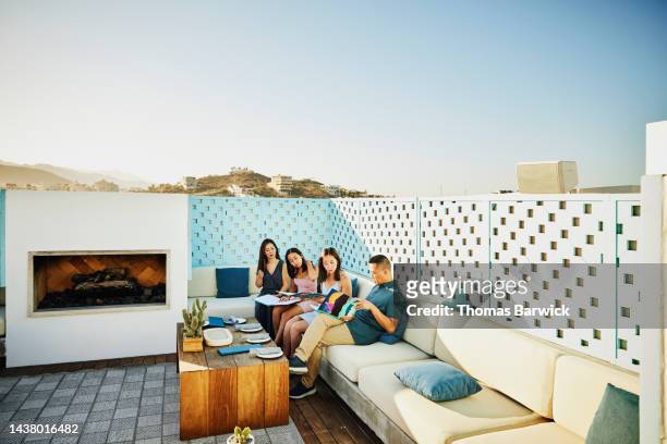 wide shot of family looking at menus at outdoor restaurant at resort - affluent dining stock pictures, royalty-free photos & images