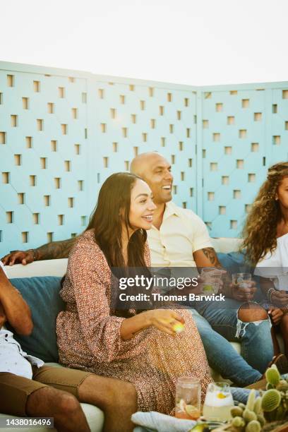 wide shot of smiling couple relaxing with family at outdoor restaurant - rooftop dining foto e immagini stock