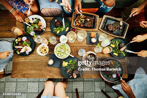 Medium overhead shot of families sharing dinner at outdoor restaurant Medium overhead shot of families sharing dinner at outdoor restaurant
