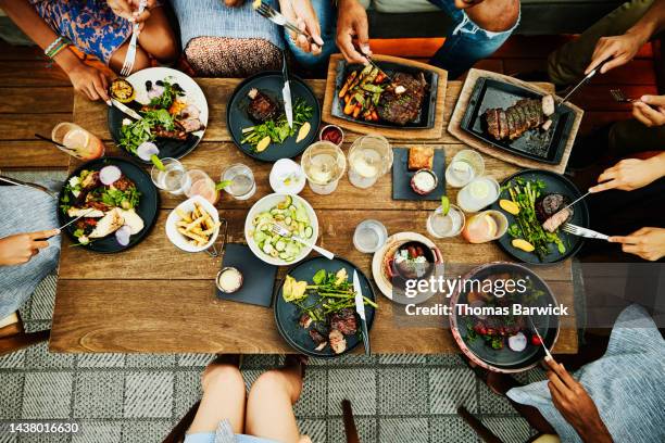 medium overhead shot of families sharing dinner at outdoor restaurant - dinner foto e immagini stock