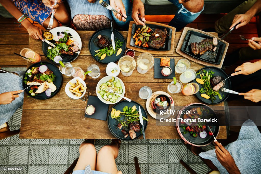 Medium overhead shot of families sharing dinner at outdoor restaurant