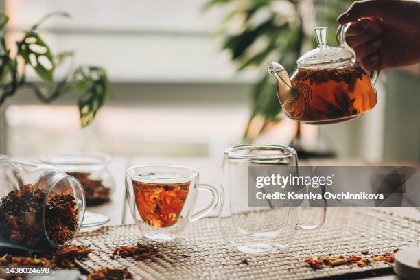 woman with cup of fresh sea buckthorn tea at wooden table, top view - herbal water stock-fotos und bilder