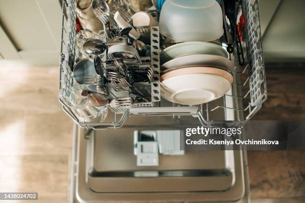 open dishwasher with clean dishes in the white kitchen - dishwasher stockfoto's en -beelden
