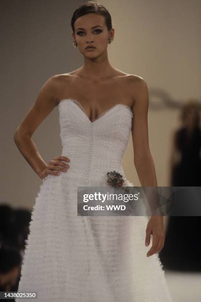 Model wearing a white strapless dress with slight ruffling from the Oscar de la Renta Spring 1996 runway show.