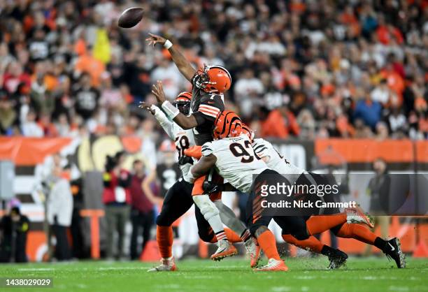 Jacoby Brissett of the Cleveland Browns throws the ball while being tackled by BJ Hill and Sam Hubbard of the Cincinnati Bengals during the second...
