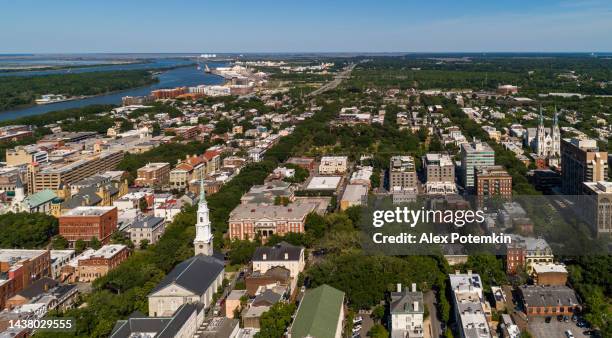 aerial view of the historic district in downtown savannah, georgia, with  independent presbyterian church in the foreground, and the remote cathedral of st. john the baptist, in the evening before sunset. - savannah imagens e fotografias de stock