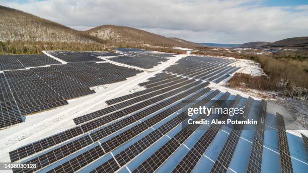 big solar farm in the appalachian mountains, pennsylvania, on a sunny winter day after a snowfall. - mount pocono pennsylvania stock pictures, royalty-free photos & images