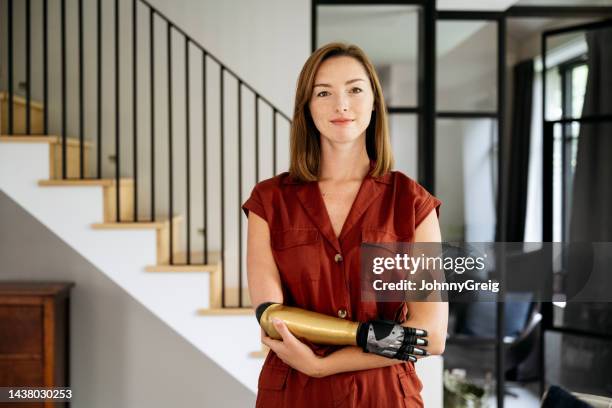 home portrait of confident young woman wearing bionic arm - bionic arm stock pictures, royalty-free photos & images