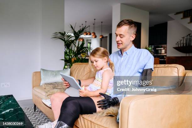 father and young daughter using digital tablet together - body positive men stock pictures, royalty-free photos & images