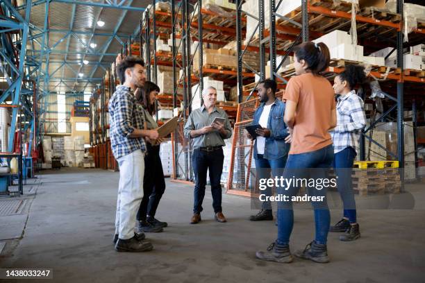 business manager talking to a group of workers at a distribution warehouse - warehouse worker stock pictures, royalty-free photos & images