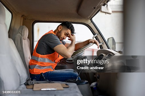 余分な時間働いた後に頭痛を抱えている疲れたトラック運転手 余分な時間働いた後に頭痛を抱えている疲れたトラック運転手