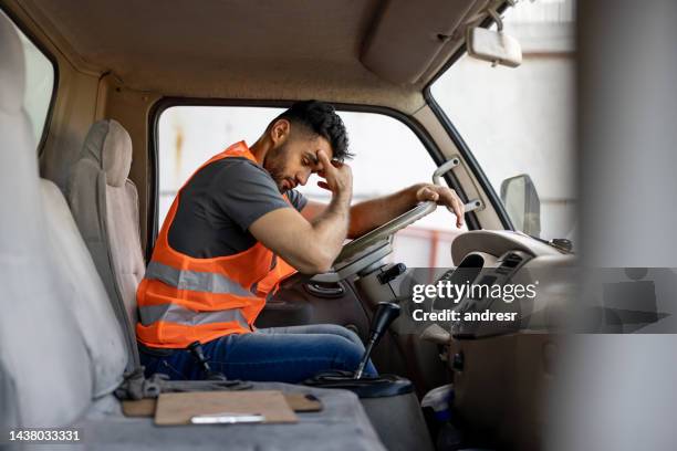 tired truck driver having a headache after working extra hours - exhaustion 個照片及圖片檔