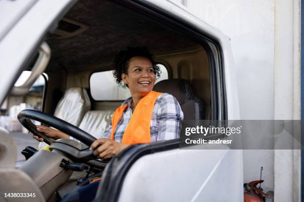 glückliche lkw-fahrerin lächelt während der fahrt - female driving stock-fotos und bilder