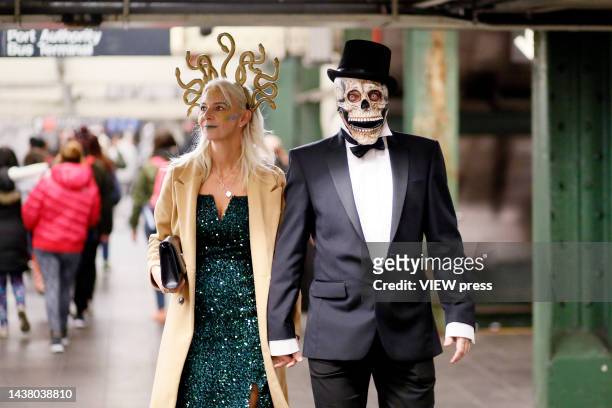 People wearing costumes walk in a subway station after the 49th Annual Halloween parade in Greenwich Village on October 31, 2022 in New York City.