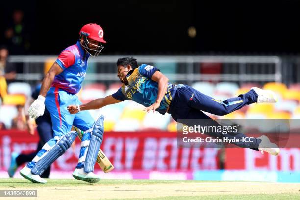 Pramod Madushan of Sri Lanka fields off his own bowling during the ICC Men's T20 World Cup match between Afghanistan and Sri Lanka at The Gabba on...