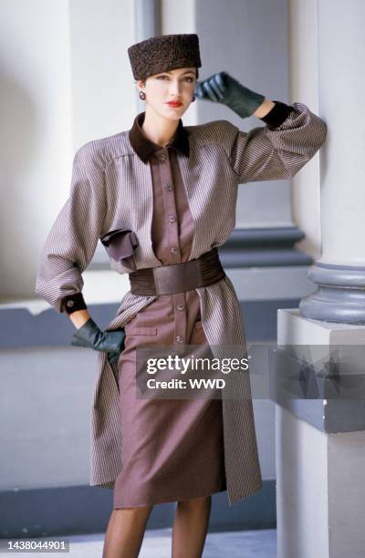 Model wearing an outfit from the Valentino fall 1984 couture collection, the one-piece double-dress in striped over solid brown wool with cashmere...