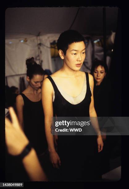 Model wearing black dress layered over a tank top backstage at the RTW Calvin Klein spring/summer '94 collection