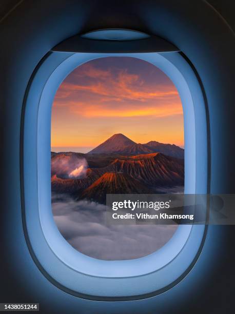 airplane windows with aerial view of bromo active volcano famous place at indonesia - business jet stock-fotos und bilder