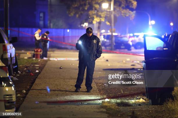 Police investigate the scene where as many as 14 people were reported to have been shot on October 31, 2022 in Chicago, Illinois. Three juveniles...