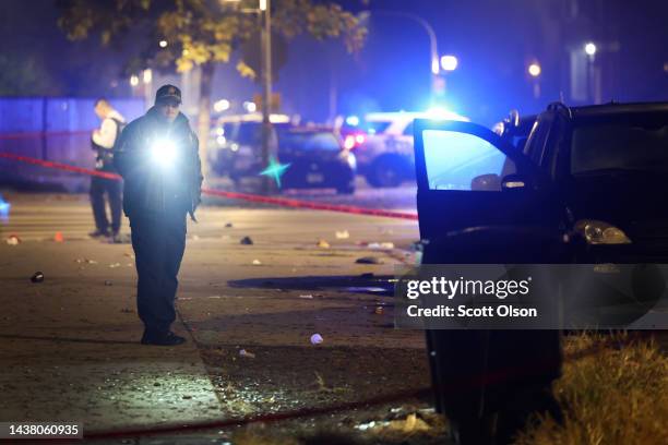 Police investigate the scene where as many as 14 people were reported to have been shot on October 31, 2022 in Chicago, Illinois. Three juveniles...